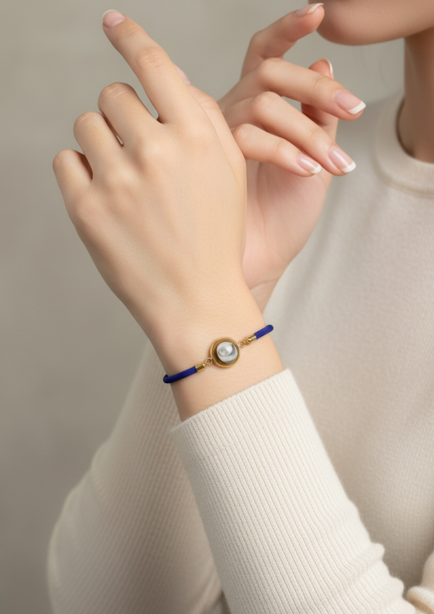 Bracelet femme avec médaillon Œil de Sainte‑Lucie au poignet, style minimaliste et marin.