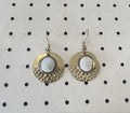 Paire de boucles d'oreilles rondes en acier inoxydable doré à texture martelée, avec cabochon Œil de Sainte-Lucie serti au centre