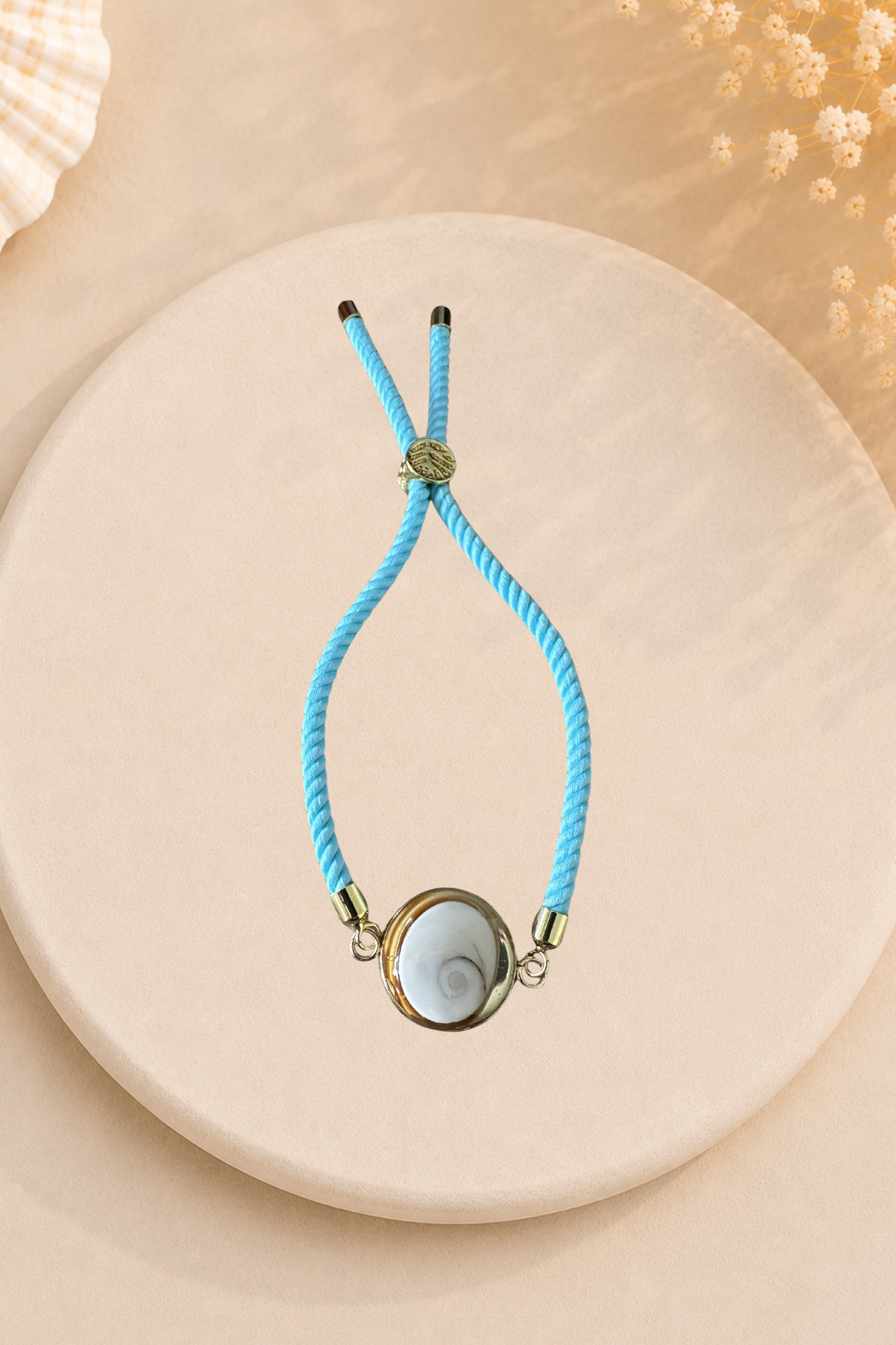Bracelet femme Œil de Sainte‑Lucie sur cordon bleu turquoise et médaillon doré. Bijou artisanal, chic et porte‑bonheur méditerranéen, élégant au quotidien.