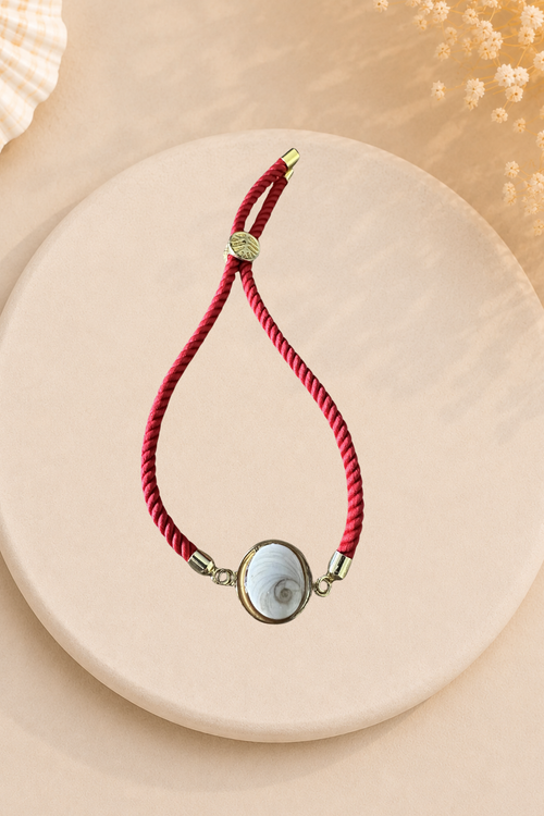 Bracelet femme Œil de Sainte‑Lucie sur cordon rouge et médaillon doré. Bijou artisanal, chic et porte‑bonheur méditerranéen, élégant au quotidien.