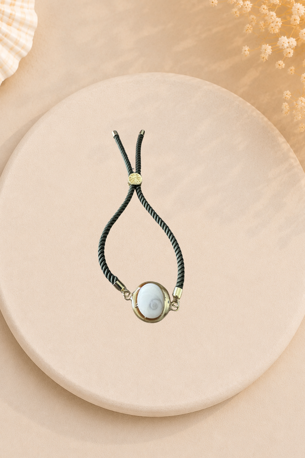 Bracelet femme Œil de Sainte‑Lucie sur cordon vert olive et médaillon doré. Bijou artisanal, chic et porte‑bonheur méditerranéen, élégant au quotidien.