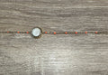 Gros plan sur le cabochon en Œil de Sainte-Lucie et les perles orange du bracelet Thetis