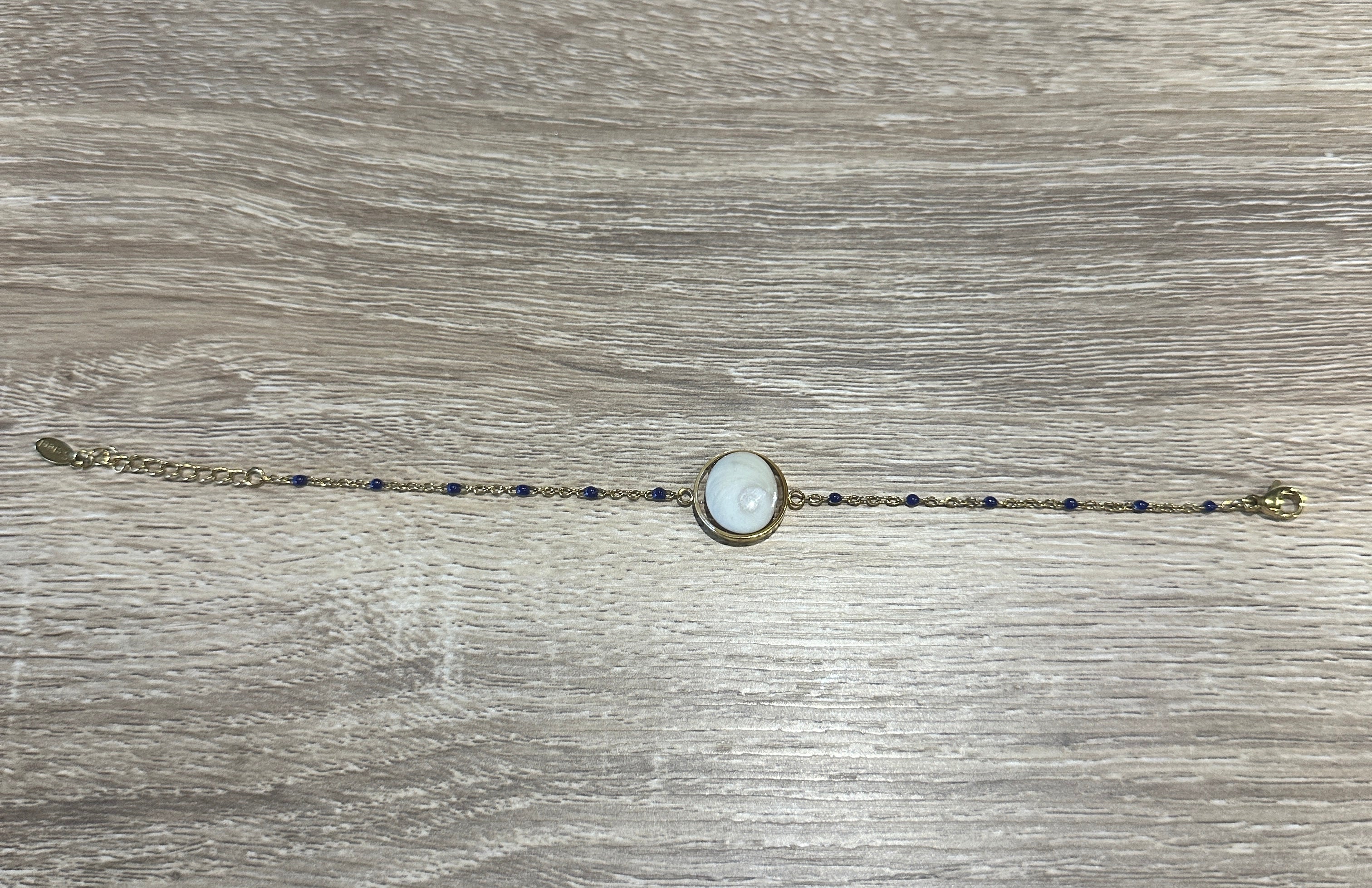 Bracelet chaîne fine dorée avec Œil de Sainte-Lucie serti et perles bleu marine réparties le long de la chaîne