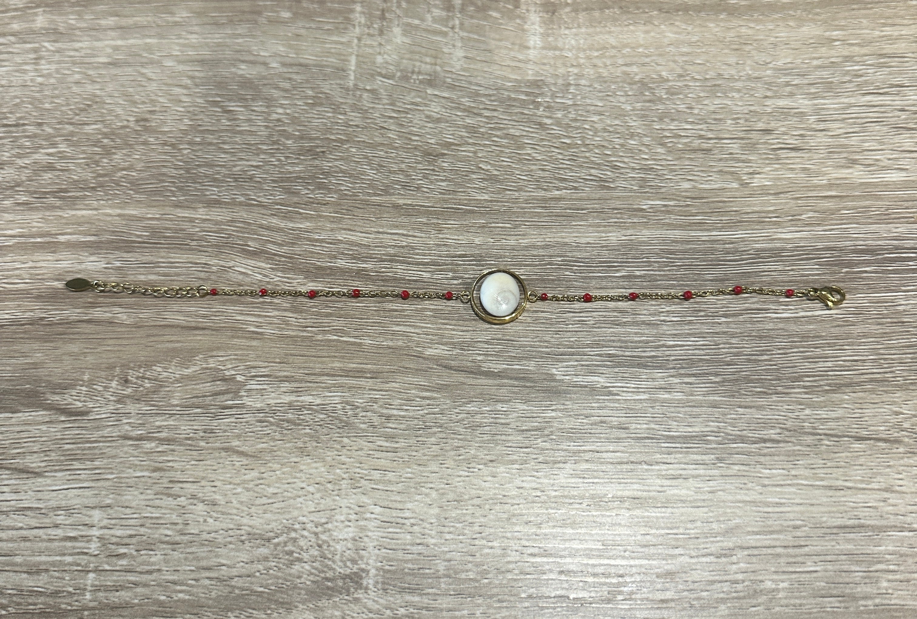 Bracelet chaîne fine dorée avec Œil de Sainte-Lucie serti et perles rouge réparties le long de la chaîne
