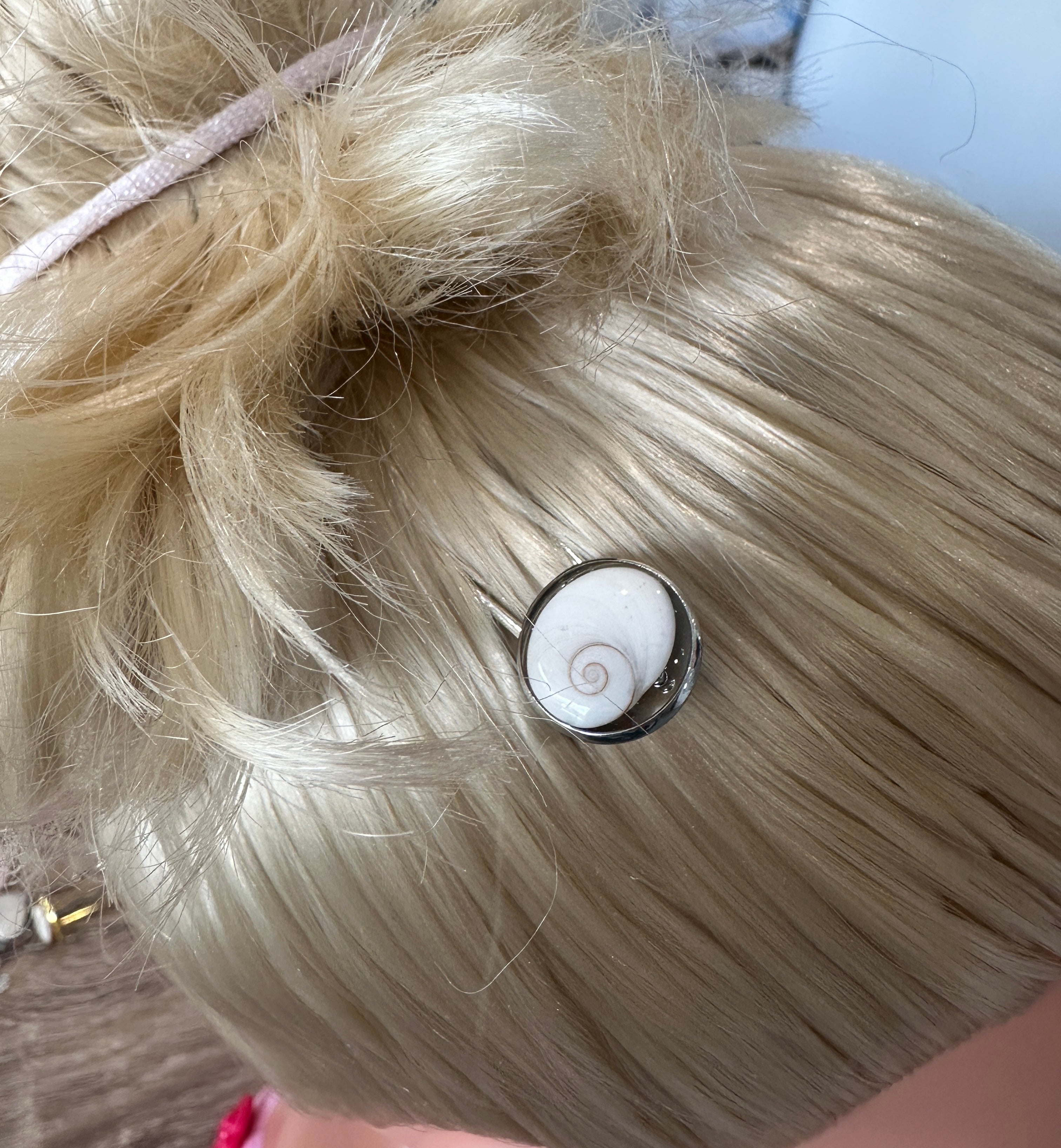 Pique à cheveux argenté avec cabochon Oeil de Sainte-Lucie, porté dans une chevelure blonde relevée
