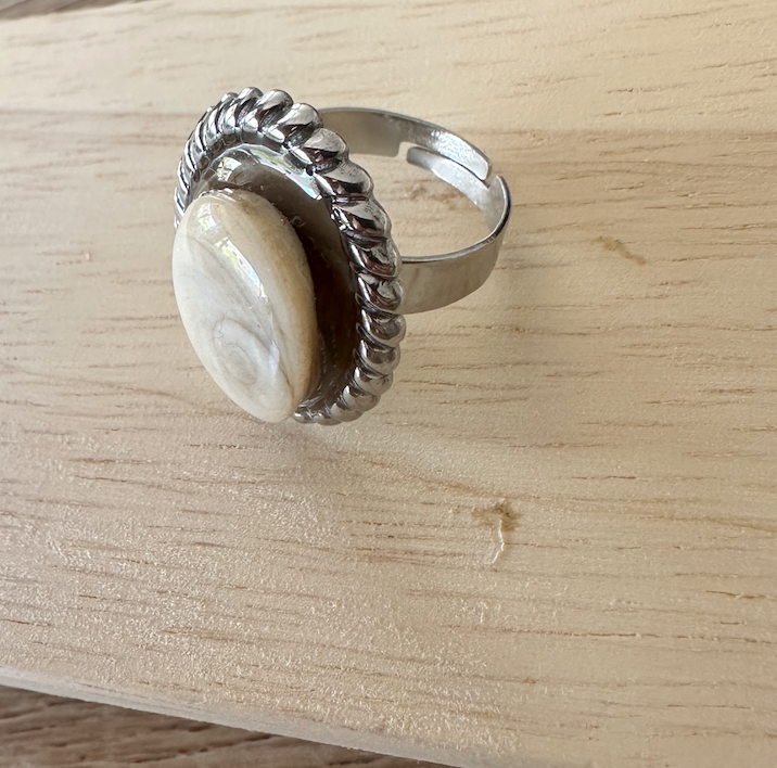 Bague Calypso argentée, vue de trois-quarts sur fond bois