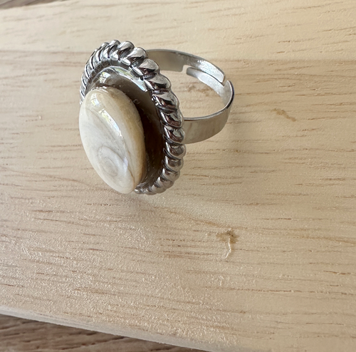 Bague Calypso argentée, vue de trois-quarts sur fond bois