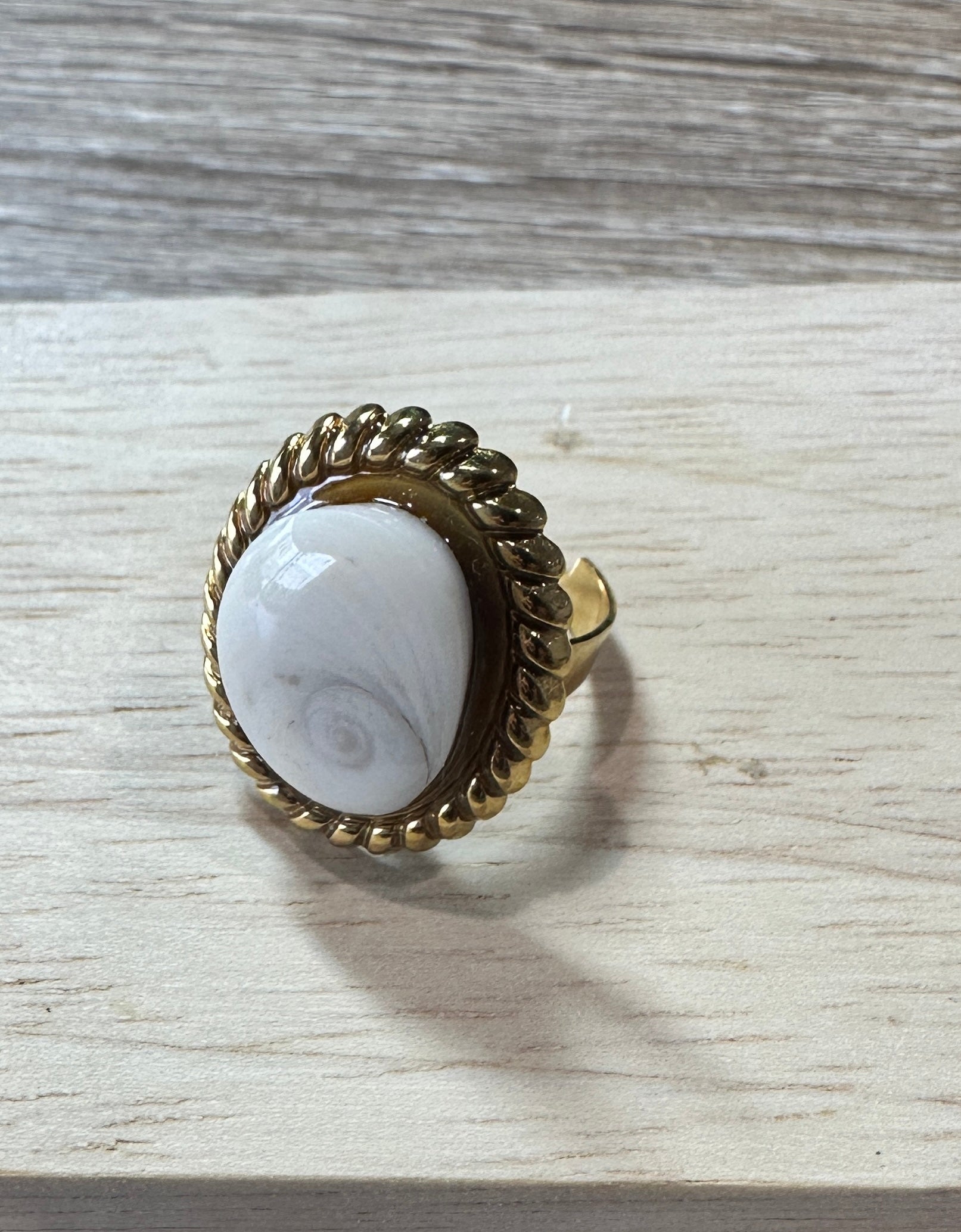 Bague Calypso dorée, vue de dessus sur fond bois