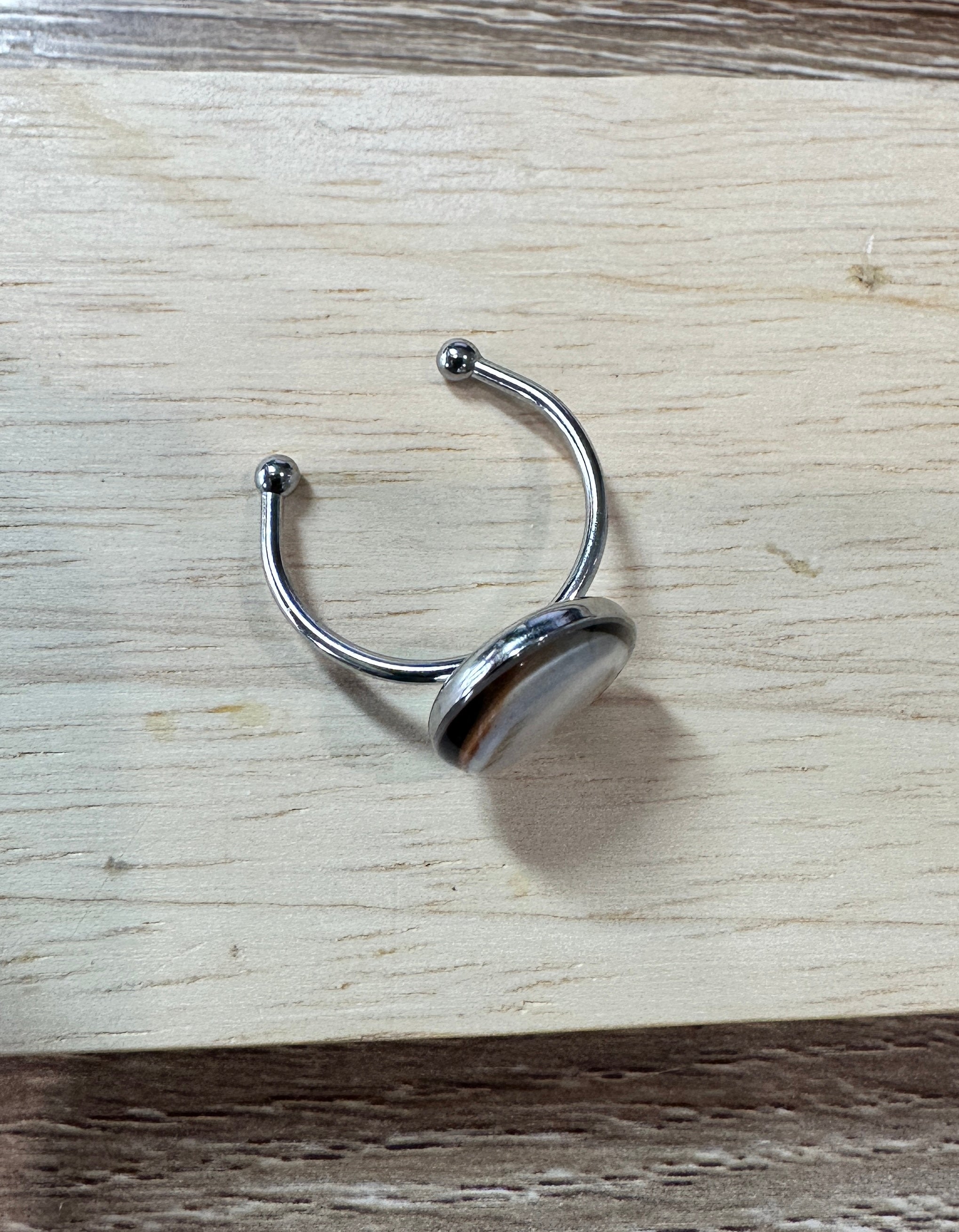 Bague Doris argentée, vue de trois-quarts sur fond bois