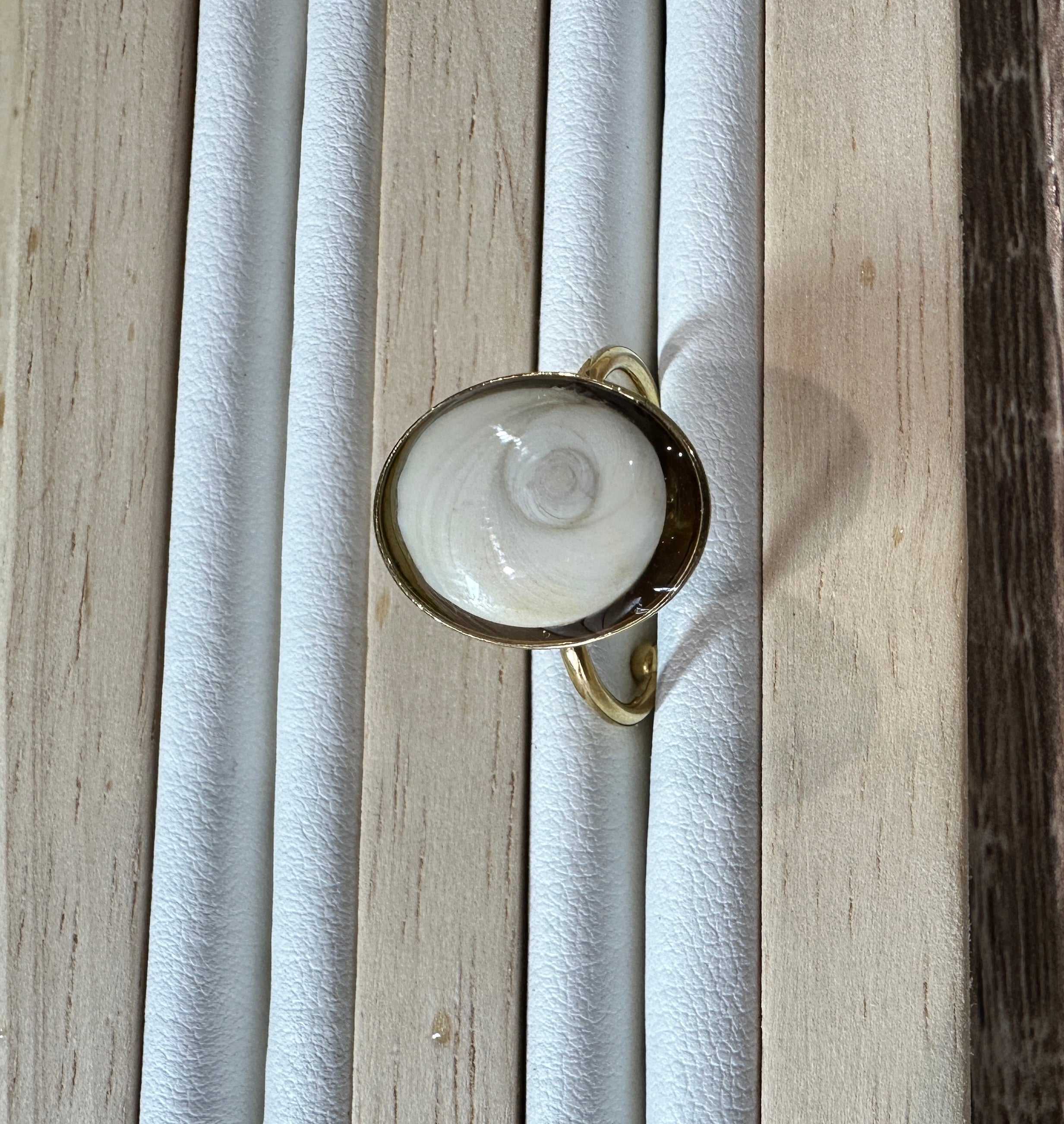 Gros plan sur la bague Doris dorée, vue de profil sur présentoir
