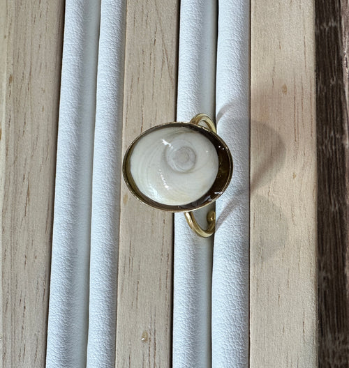 Gros plan sur la bague Doris dorée, vue de profil sur présentoir
