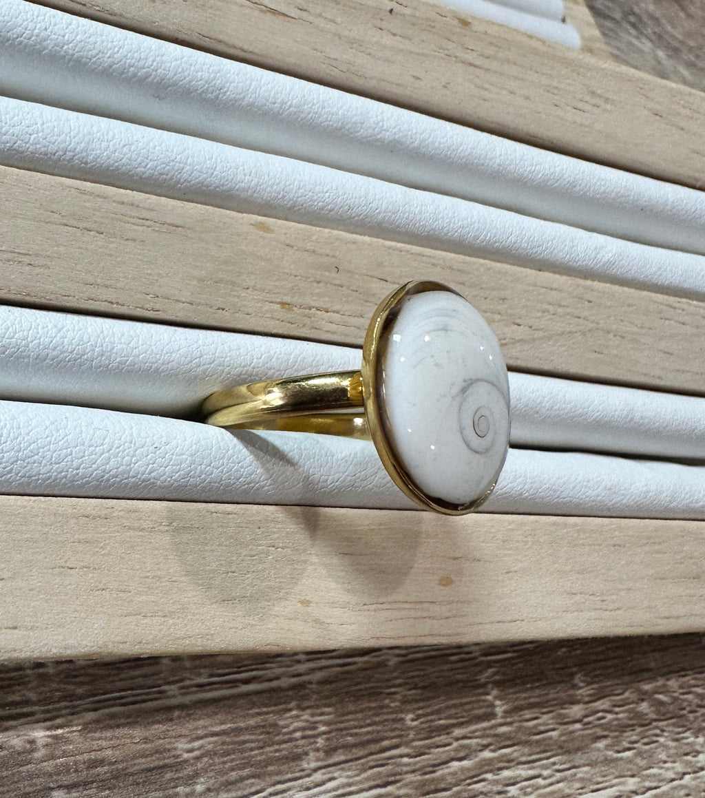 Gros plan sur la bague Iris dorée, vue de profil sur présentoir