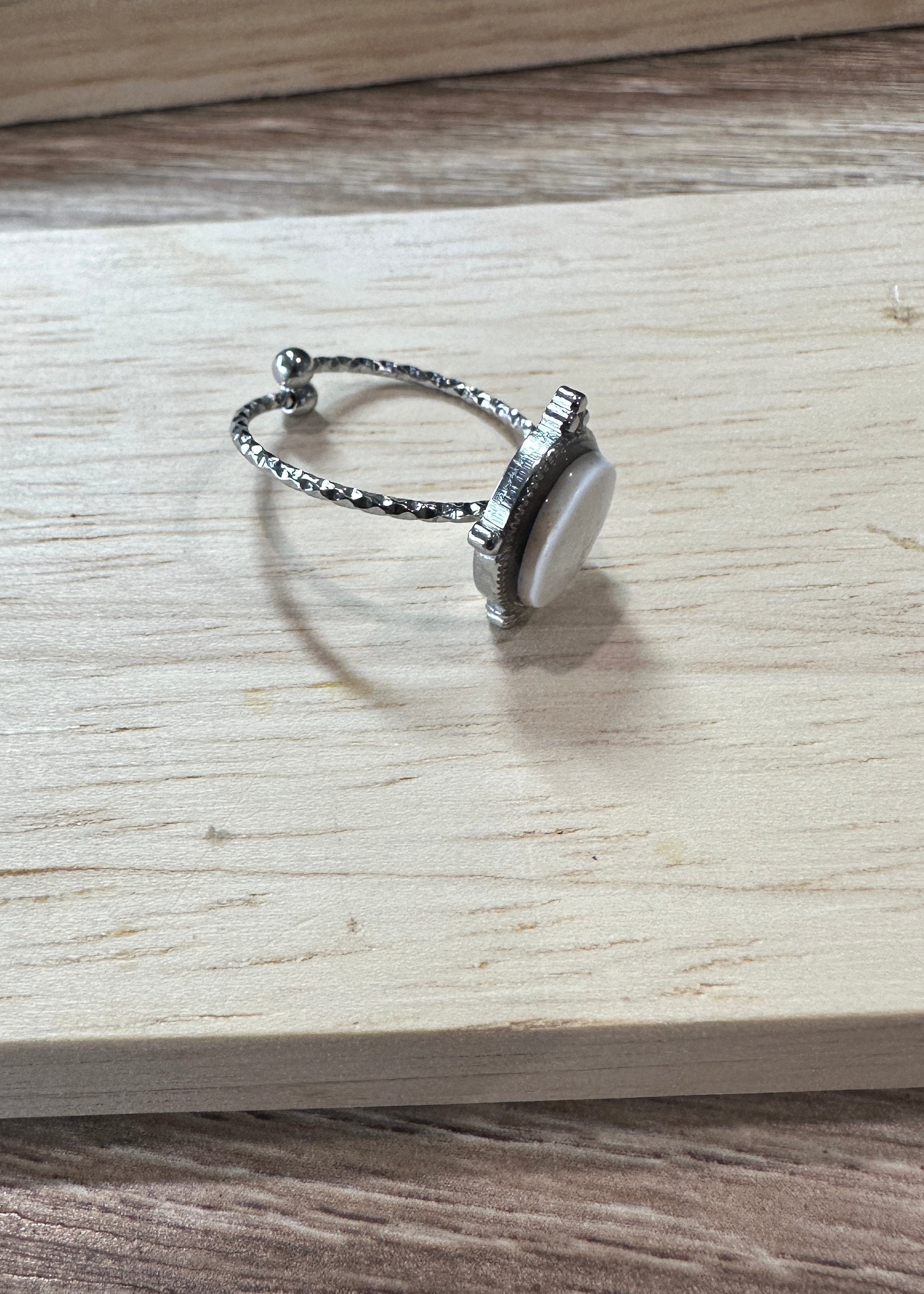 Bague Ondine argentée, vue de trois-quarts sur fond bois