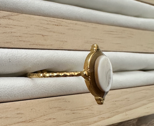 Gros plan sur la bague Ondine dorée, vue de profil sur présentoir