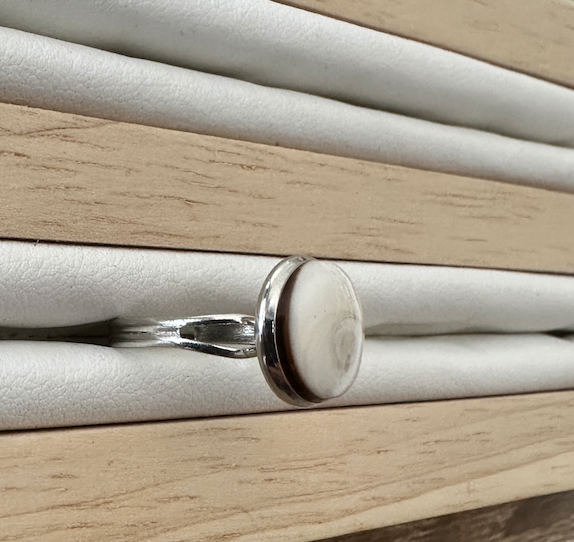 Gros plan sur la bague Thea argentée, vue de profil sur présentoir
