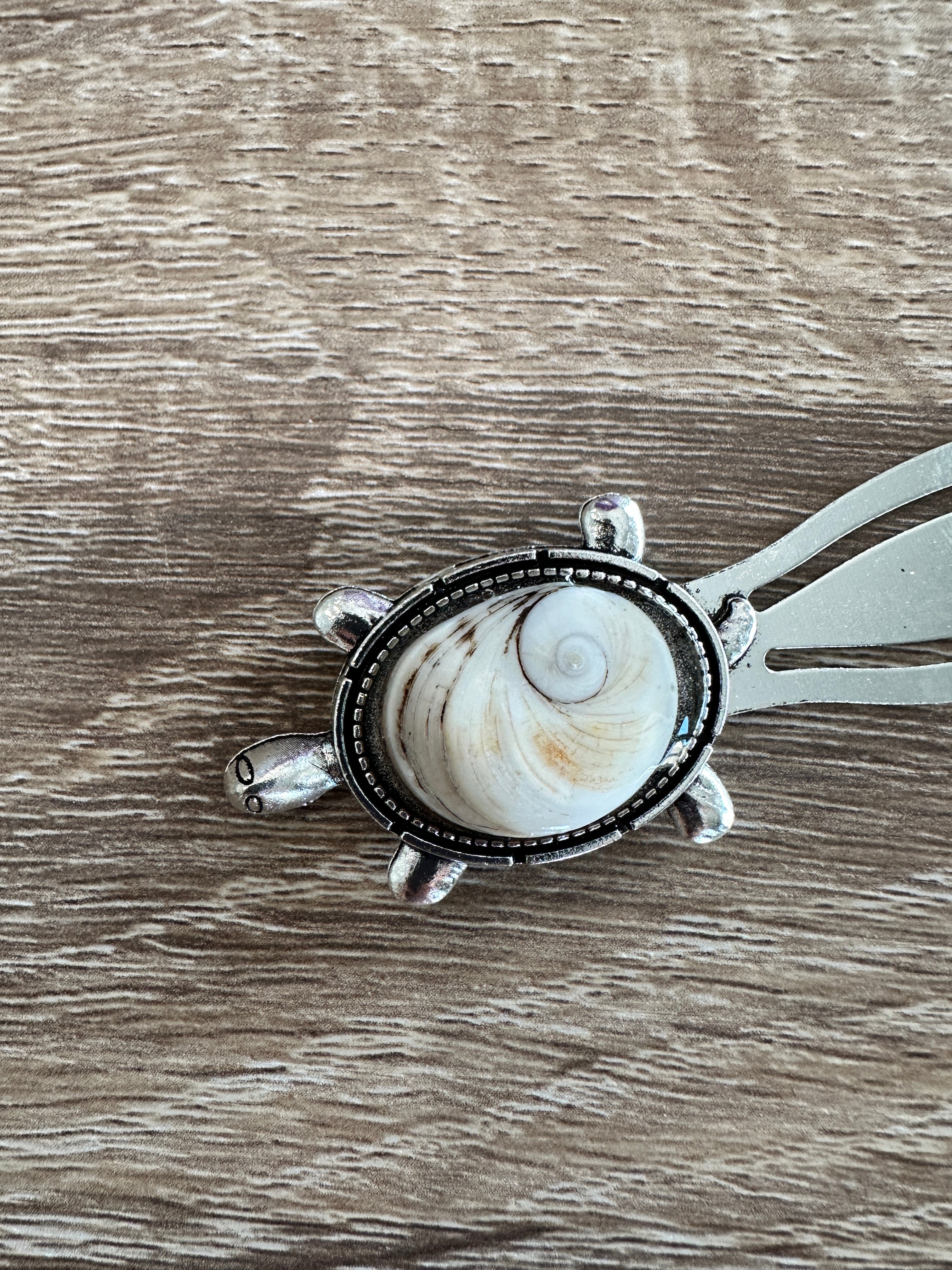 Gros plan sur le marque-page argenté en forme de tortue avec cabochon Œil de Sainte-Lucie