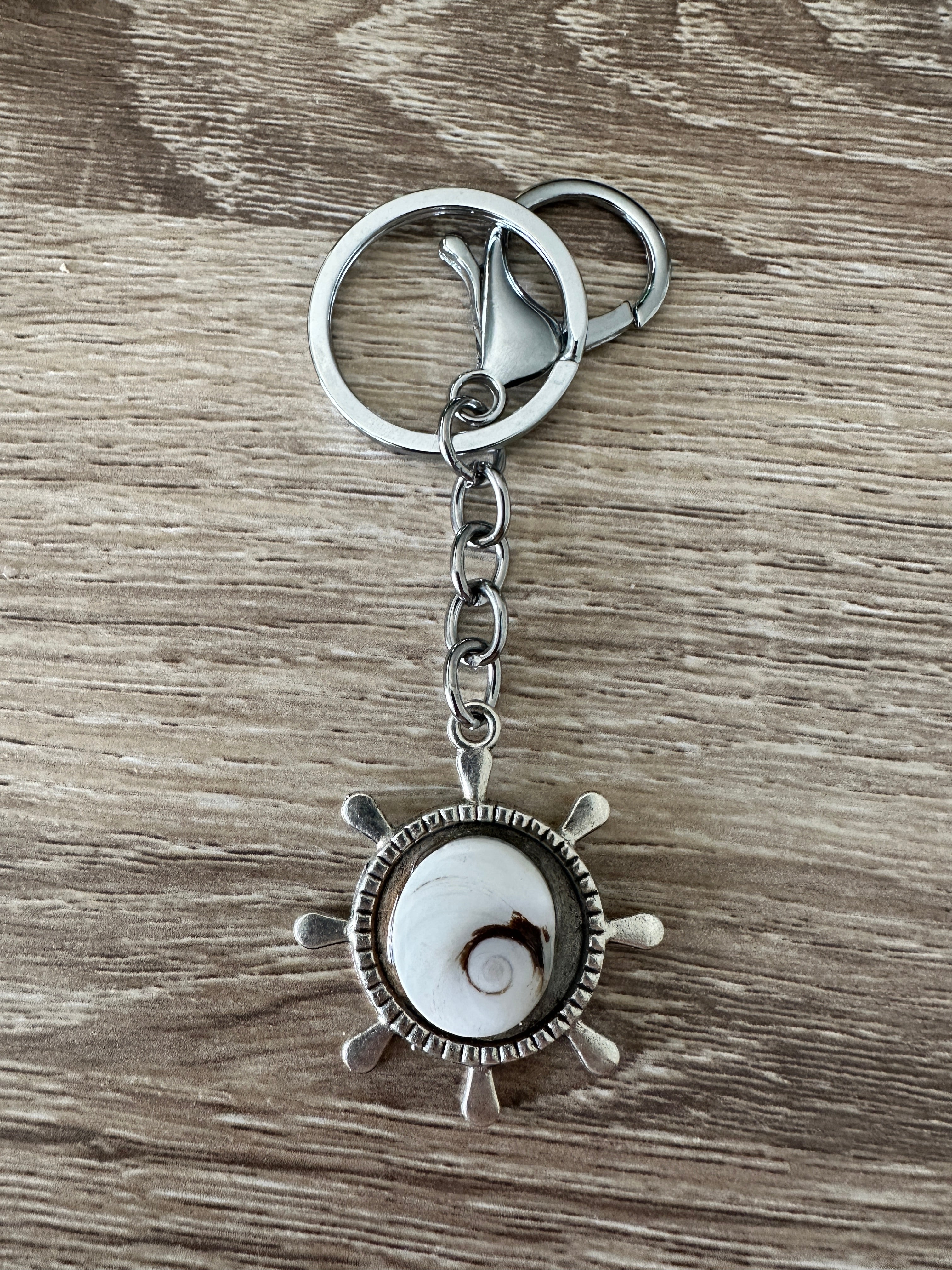 gouvernail-oeil-sainte-lucie-clair	Porte-clés gouvernail argenté avec cabochon Œil de Sainte-Lucie clair