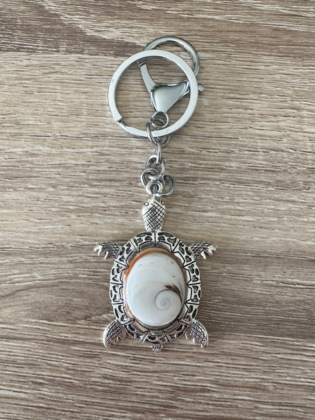 Porte-clés tortue argenté avec cabochon Œil de Sainte-Lucie clair, posé à plat